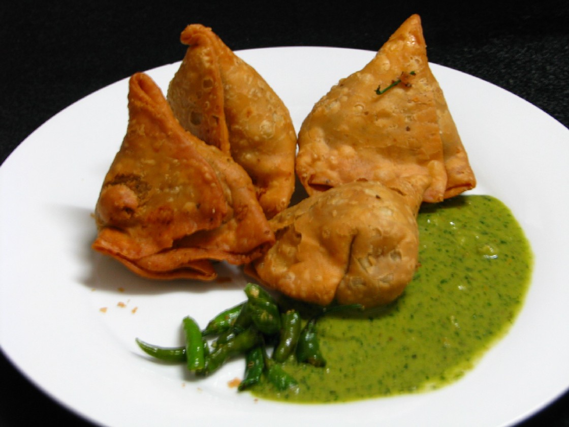 Crispy vegetarian samosa starter served with green chutney